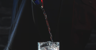 Bartender using Skyflo Pro liquor control system to pour liquor into glass