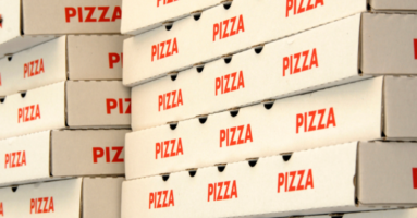 White pizza boxes with red writing saying pizza, stacked