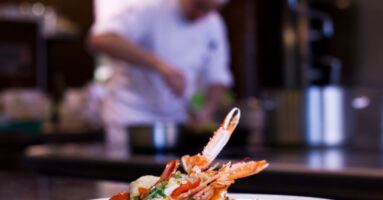 Plate of food with chef in background