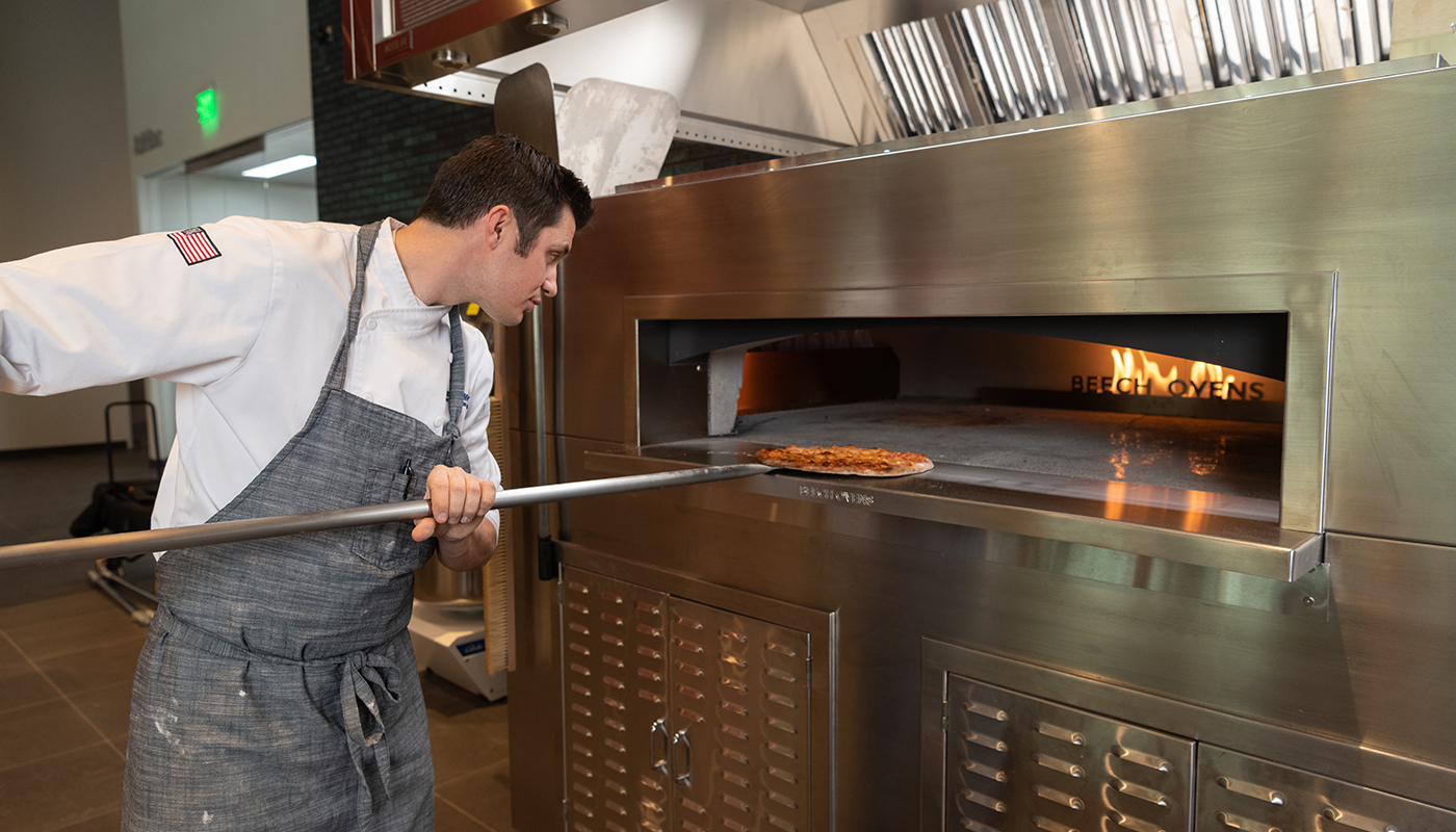Chef Kyle Wilson cooking pizza in a Beech Oven