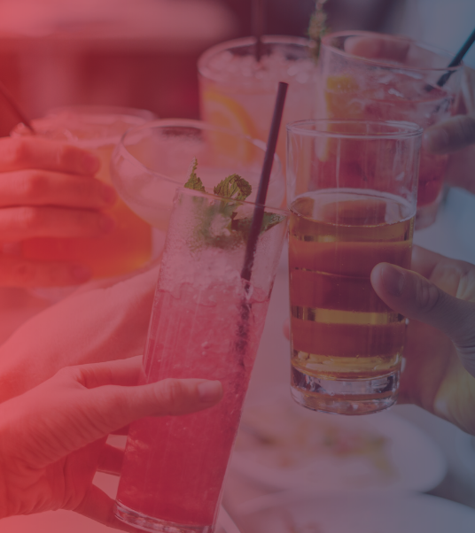 Two people toasting with cocktail glasses. Color overlay for drama.